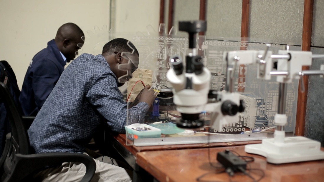 Two men work on gearboxes in a lab