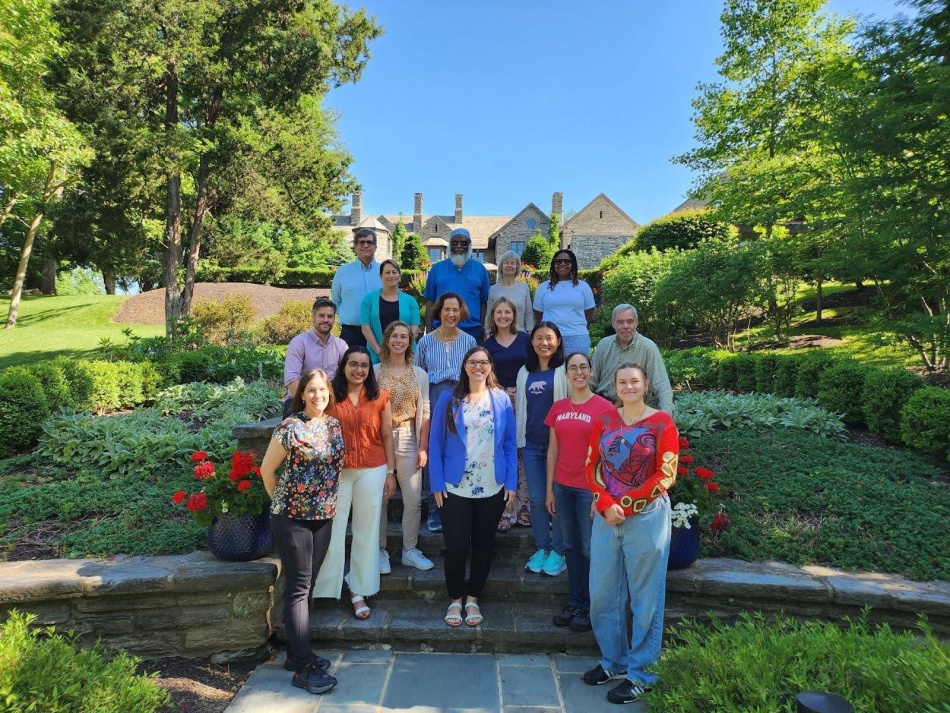 A photo of Villanova University faculty smiling on a green campus.
