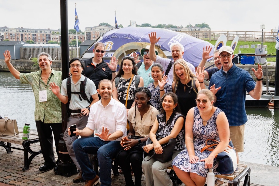 EOP Network members posing with Baltimore Harbor’s iconic Mr. Trash Wheel, a trash interceptor powered by a water wheel and solar cells.